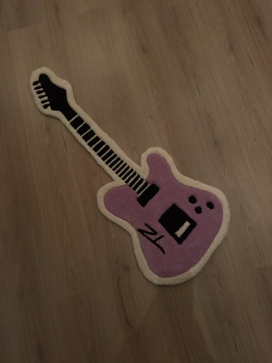 Teppe formet som en rosa elgitar med hvit kant